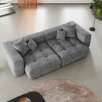Gray sectional loveseat sofa in a modern living room setting with a round rug.