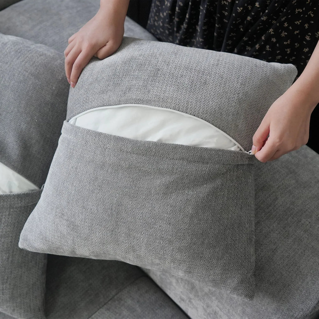 Close-up of an unzipped pillow case of a gray sofa