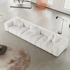White 3-seater sofa in a modern living room with a rug and lamp.