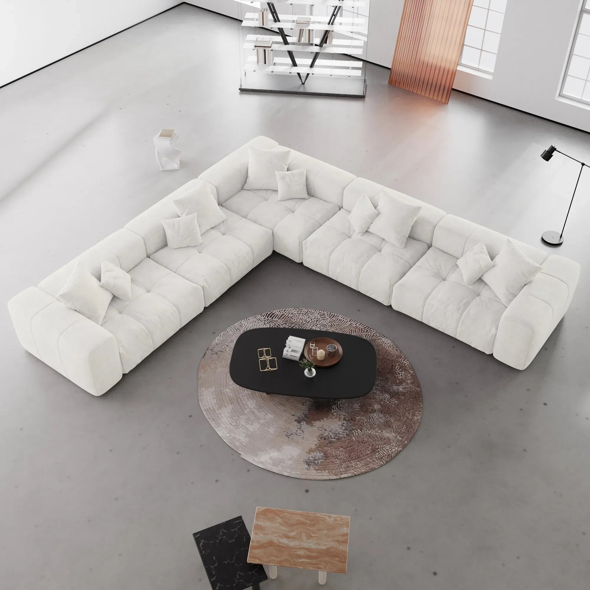 Modern white V-shaped corner sectional sofa in a minimalistic living room with a round coffee table.