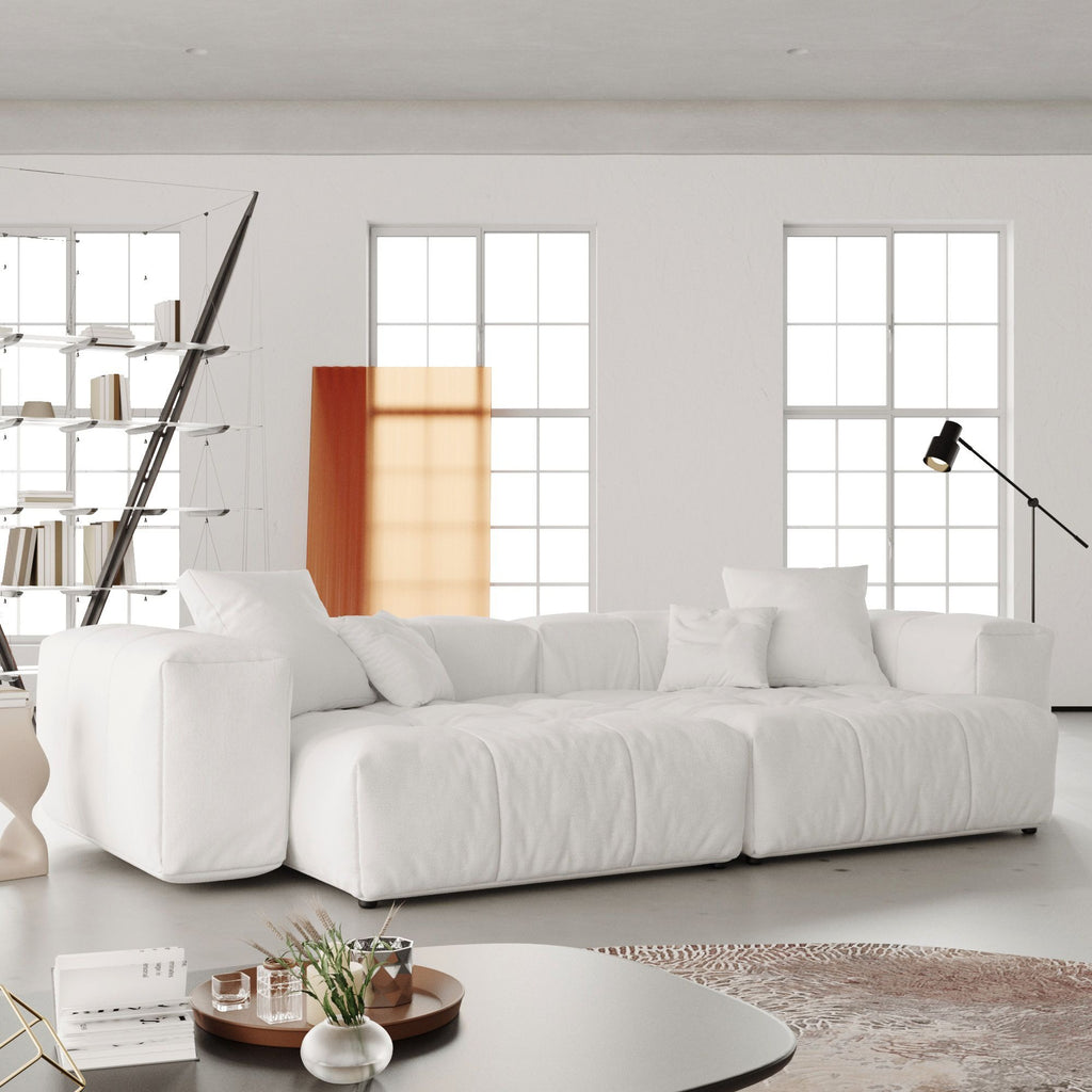 White loveseat sofa in a modern living room with large windows