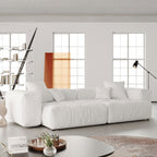White loveseat sofa in a modern living room with large windows