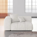 White armrest seat with cushions in a modern room with large windows.
