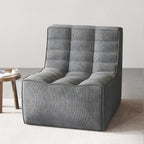 A black chenille accent chair with a minimalist design in a studio light