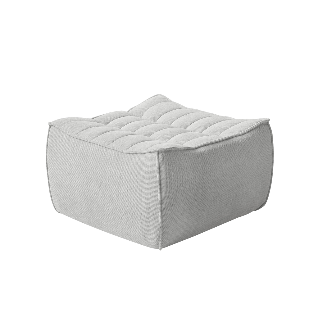 Light gray ottoman with tufted design on a white background