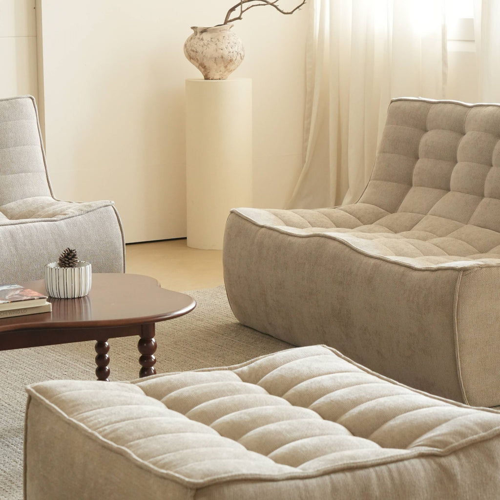 Beige floor 2-seater sofa and ottoman in a minimalistic living room