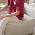 Person sitting on a khaki waffle floor ottoman