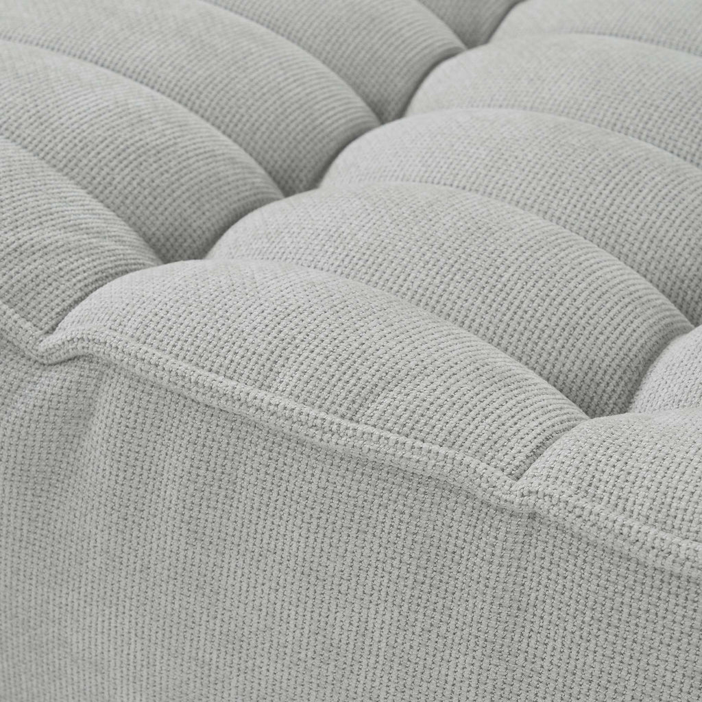 Close-up of a seat of a gray waffle sofa