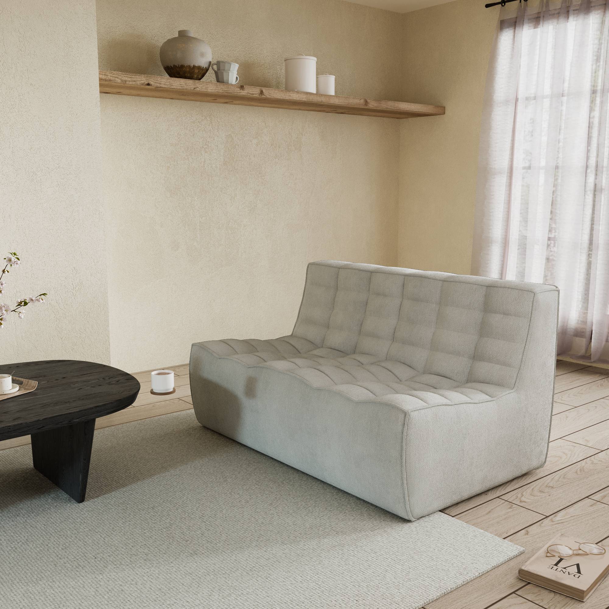 A light gray cotton-linen 2-seater sofa with an ergonomic caterpillar design, placed in a room with a window, curtains, a small round table, and a book on the floor.