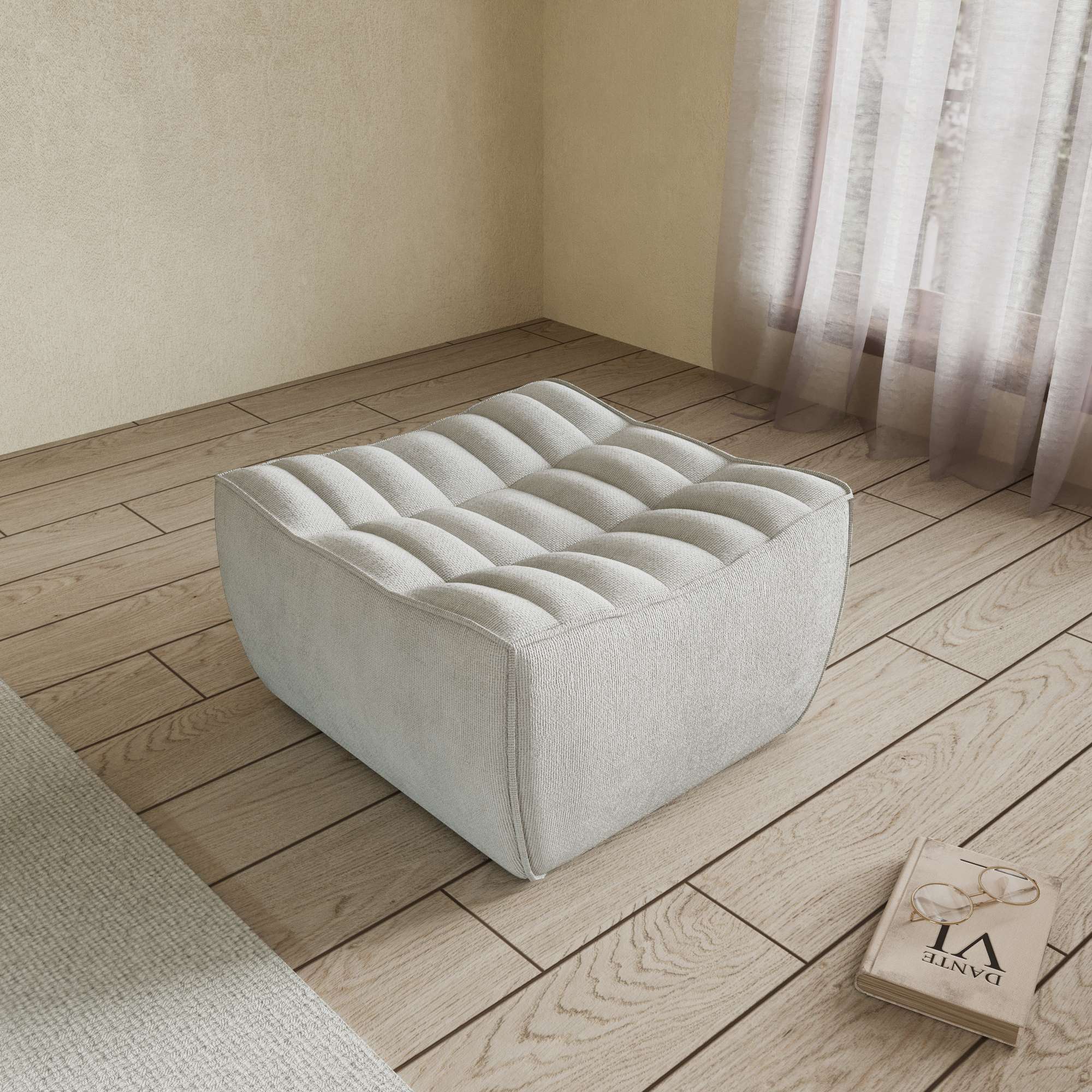A light gray chenille ottoman with a minimalist design, placed on a wooden floor with a large window in the background.