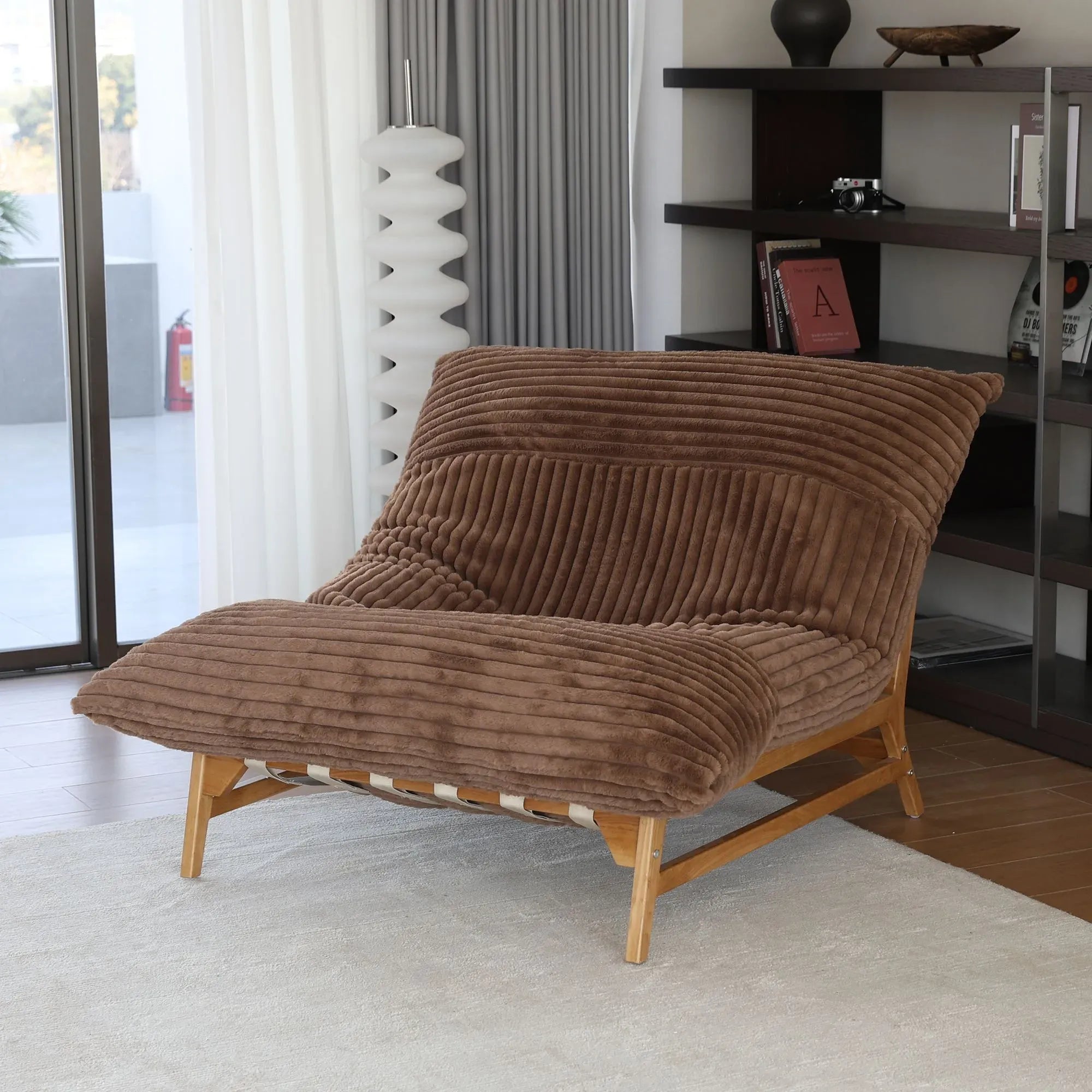 Brown textured sofa chair in a room with a bookshelf and window.