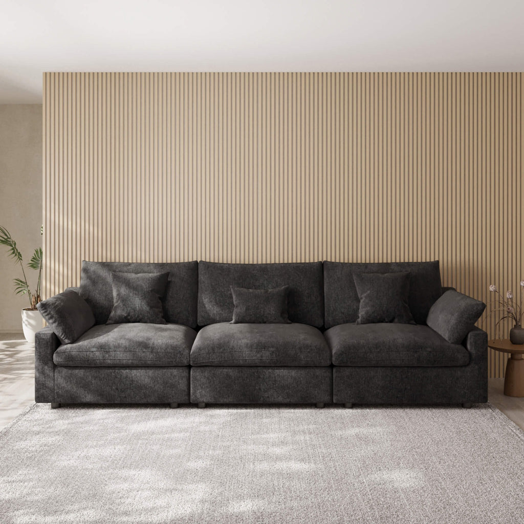 Black 3-seater sofa in a living room with striped wallpaper