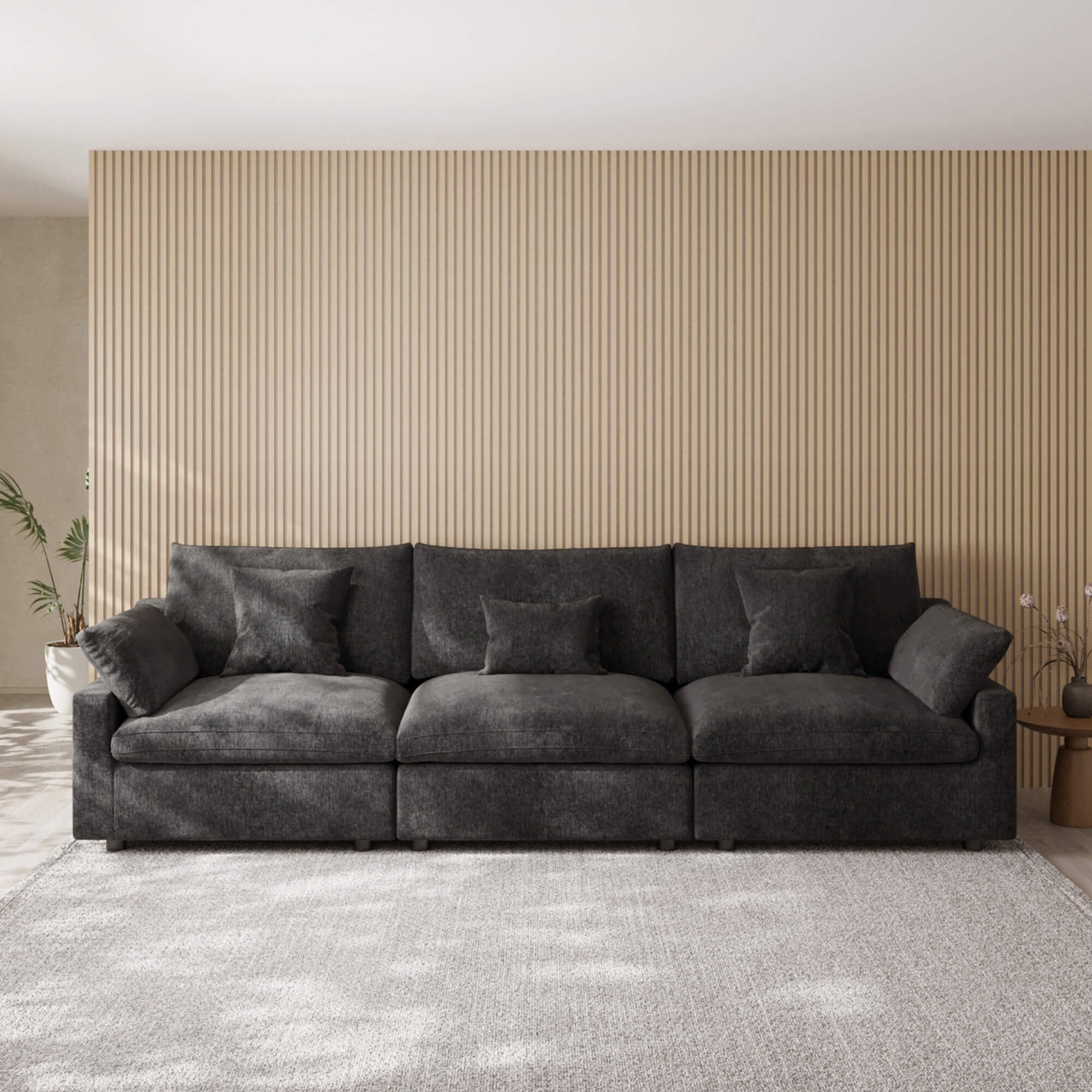 Black 3-seater sofa in a living room with striped wallpaper