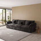 Black 3-seater sofa in a modern living room with a striped wall and large windows.