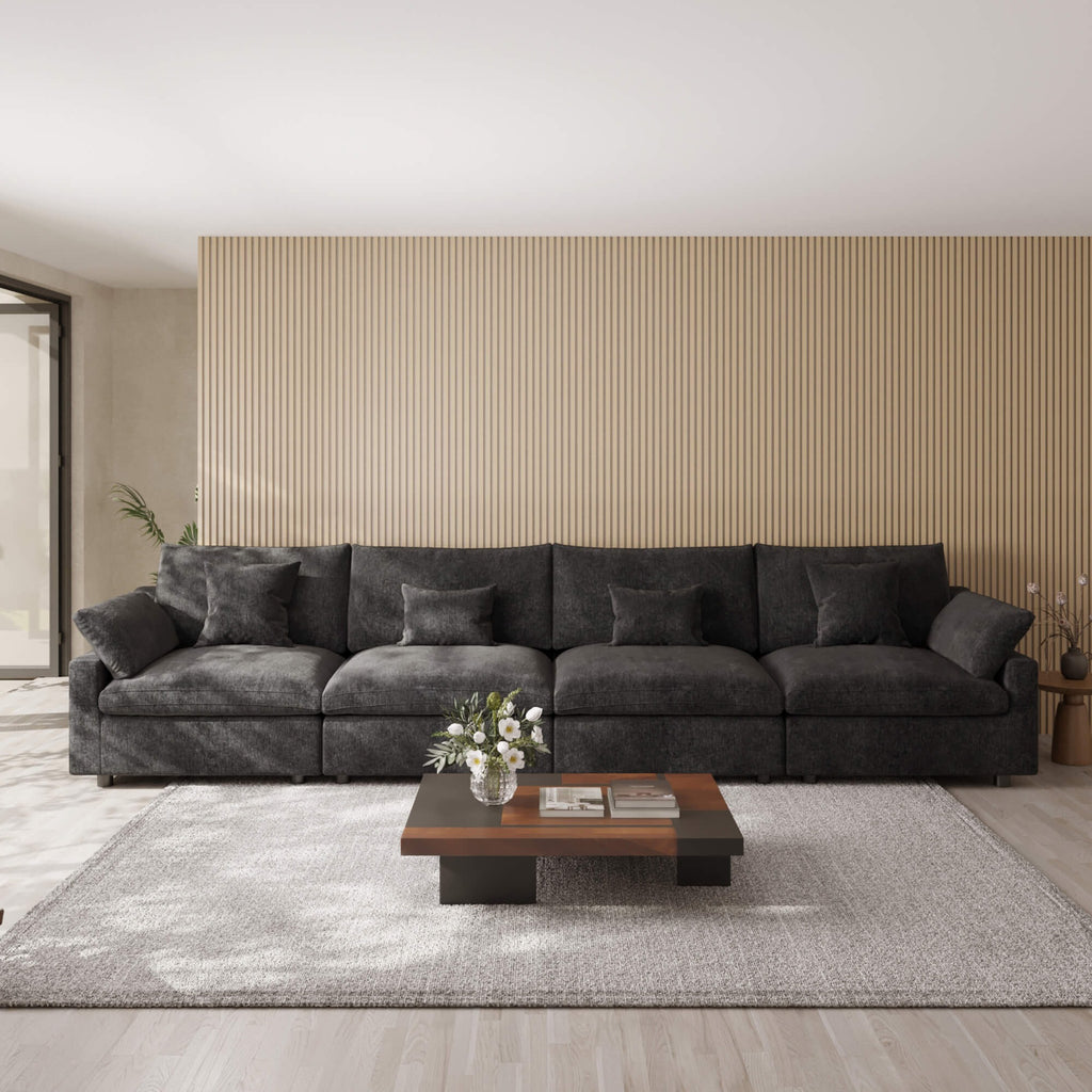 Black 4-seat sectional sofa in a modern living room with a coffee table and decorative items.