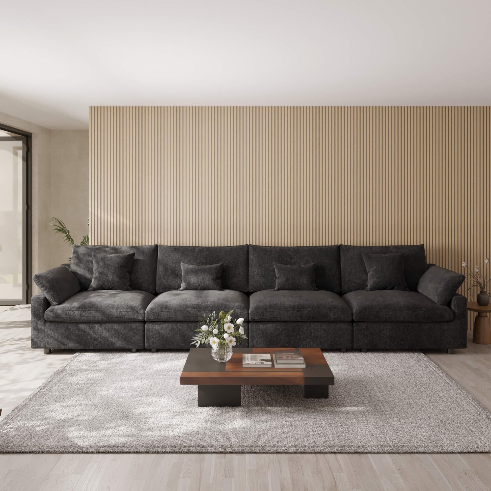 Black 4-seat sectional sofa in a modern living room with a coffee table and decorative items.
