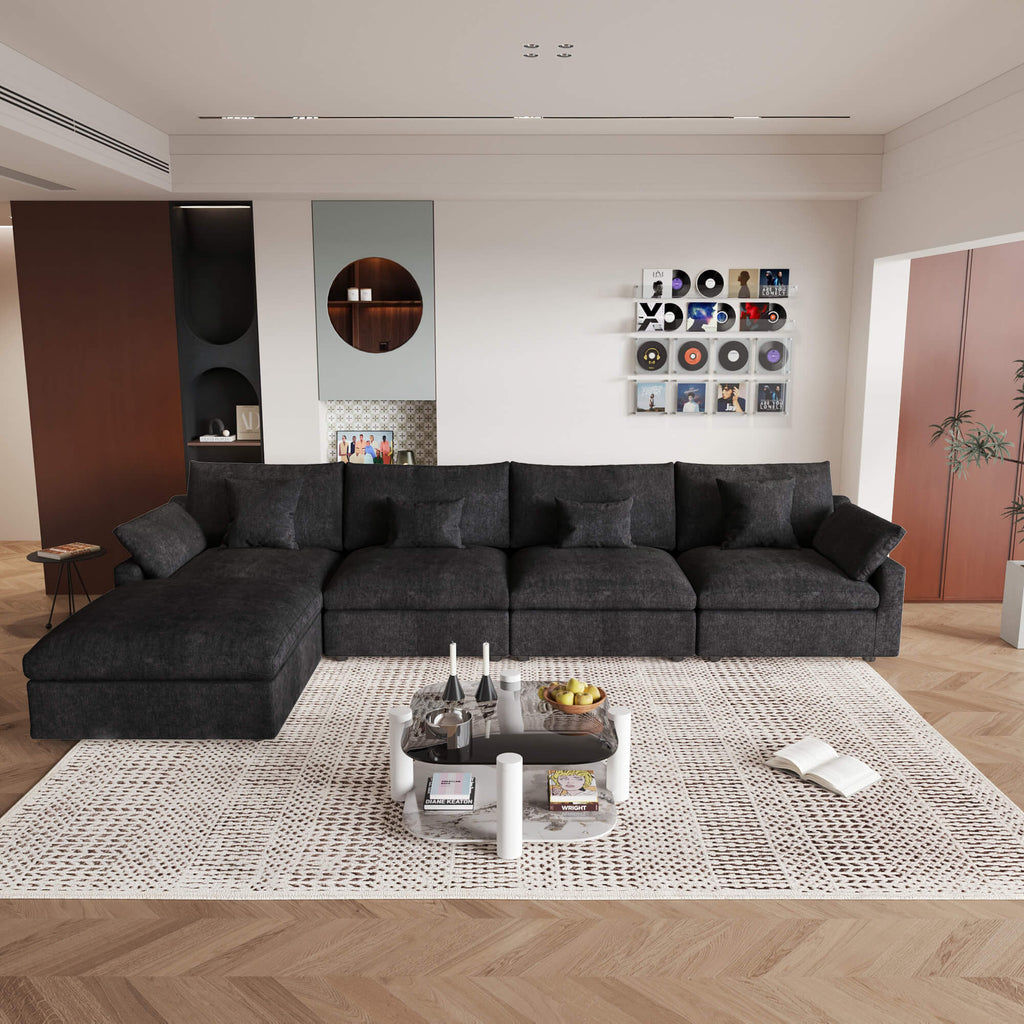 A large, black washable cloud sectional 5-seat sofa with removable cushions and an ottoman, placed in a living room setting.