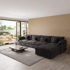 Modern living room with a black 5-seat sectional sofa with ottoman, coffee table, and decorative elements.
