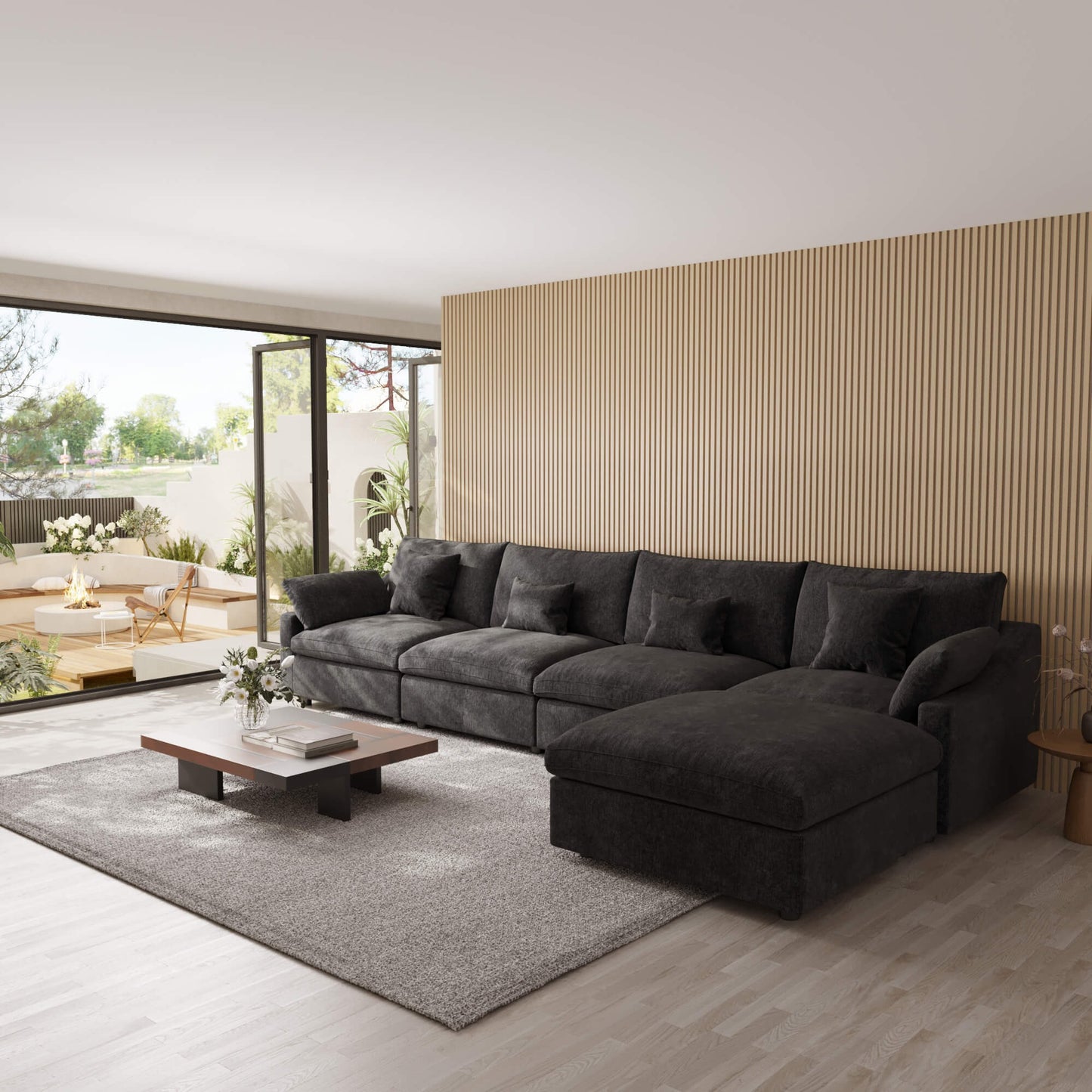 Modern living room with a black 5-seat sectional sofa with ottoman, coffee table, and decorative elements.