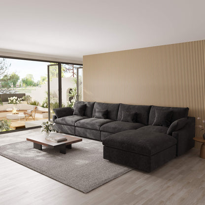 Modern living room with a black 5-seat sectional sofa with ottoman, coffee table, and decorative elements.