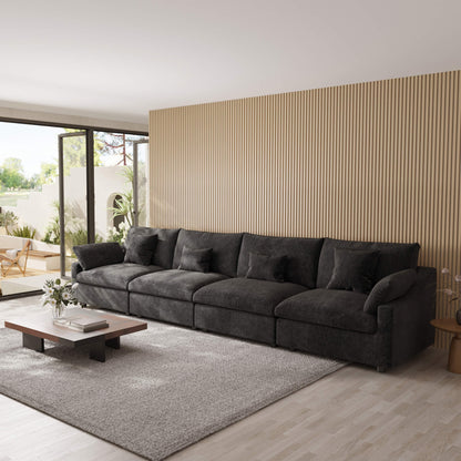 Modern living room with a large black 4-seat sectional sofa, coffee table, and decorative elements.