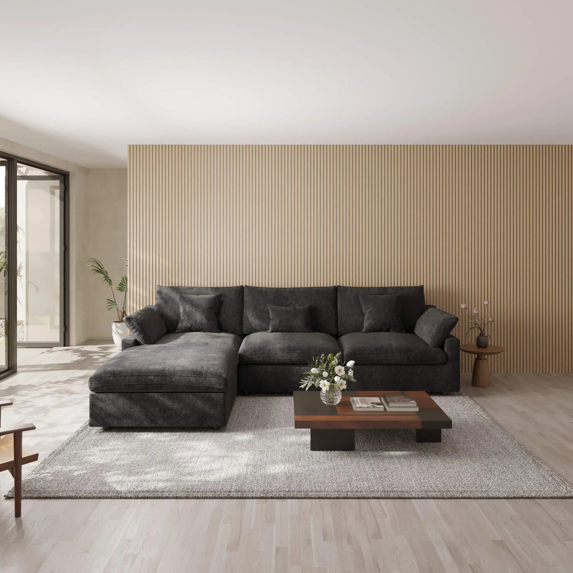 Black L-shaped sectional sofa in a modern living room with a wooden coffee table and decorative items.