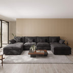 Black U-shaped sectional sofa in a modern living room with a coffee table and decorative items.