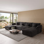 Modern living room with a black U-shaped sectional sofa, coffee table, and decorative elements.