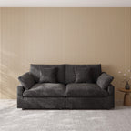 Black loveseat couch in a room with a striped wall and small table.