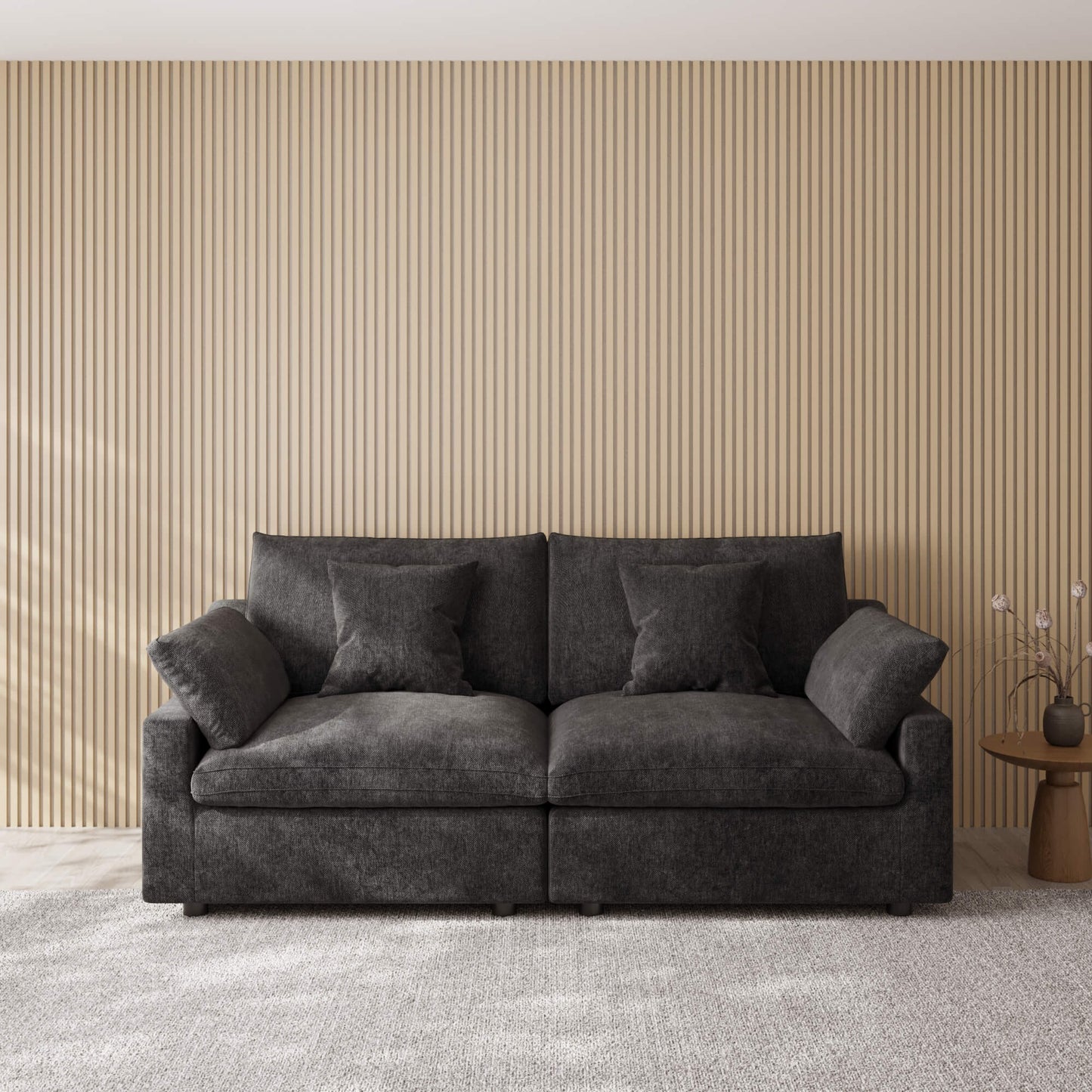 Black loveseat couch in a room with a striped wall and small table.