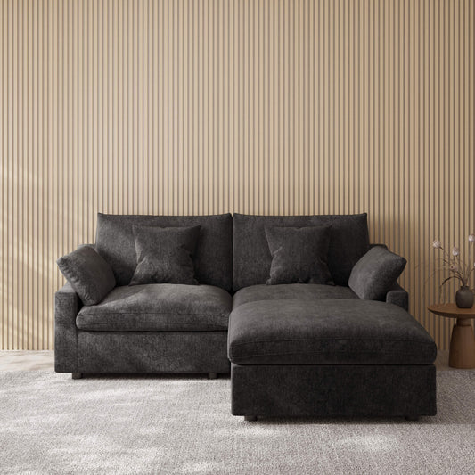 Black sectional chaise lounge loveseat in a room with striped wallpaper
