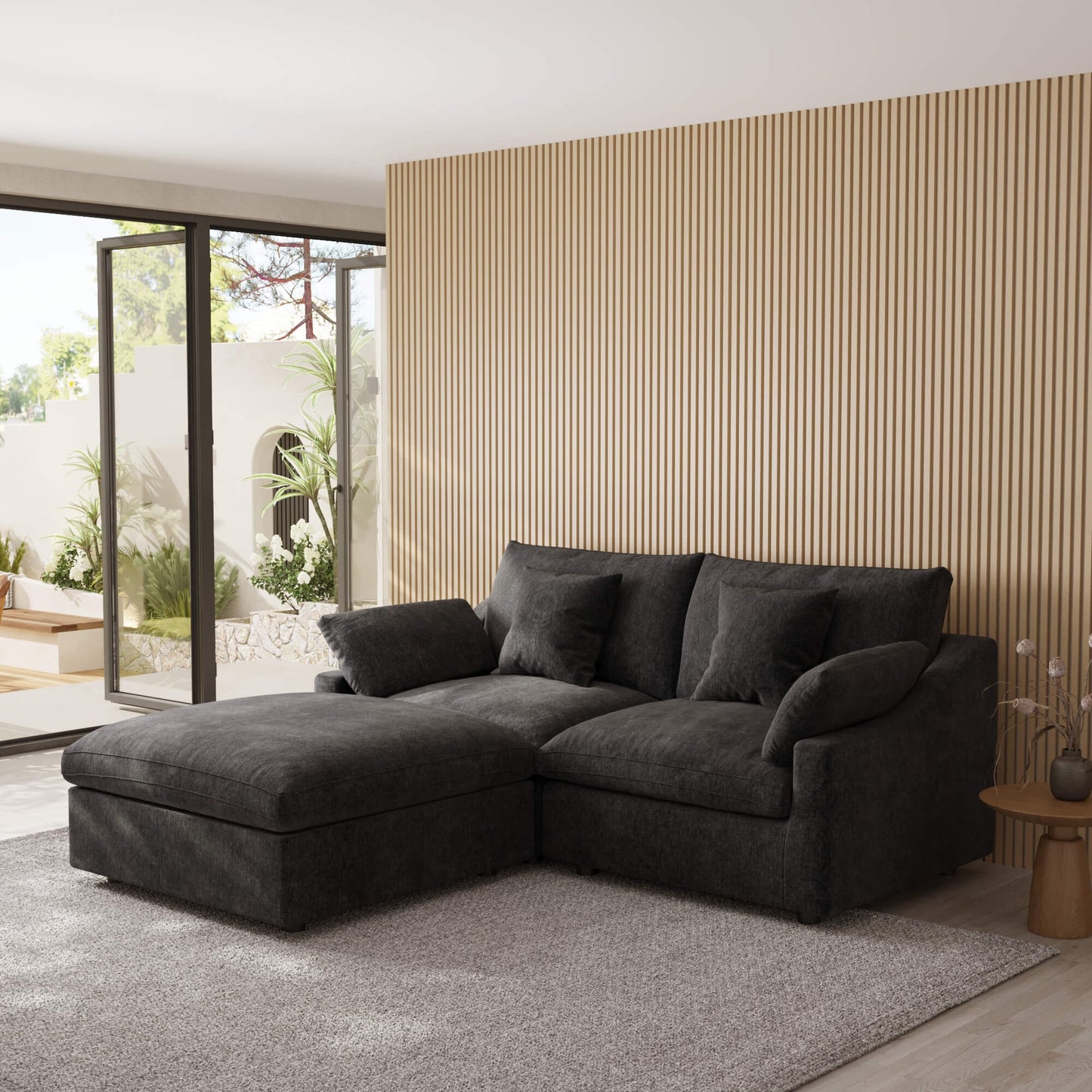 Black sectional sofa in a modern living room with a striped wall and patio door.