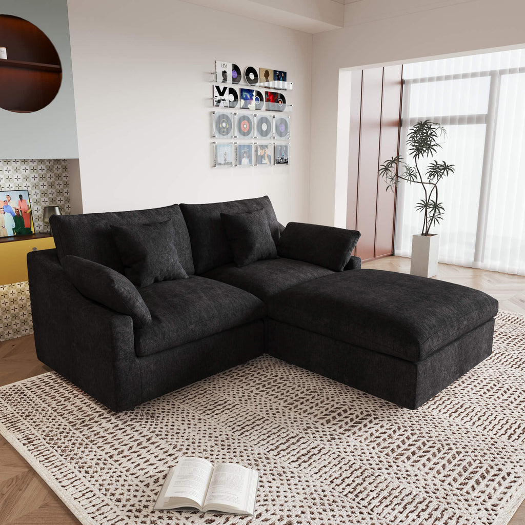 A black linen loveseat with ottoman, featuring a washable cloud design, placed on a patterned rug in a room with a record collection on the wall.