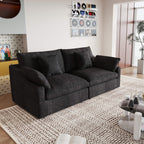 A black loveseat couch, featuring a minimalist design with removable cushions, placed in a room with modern decor.