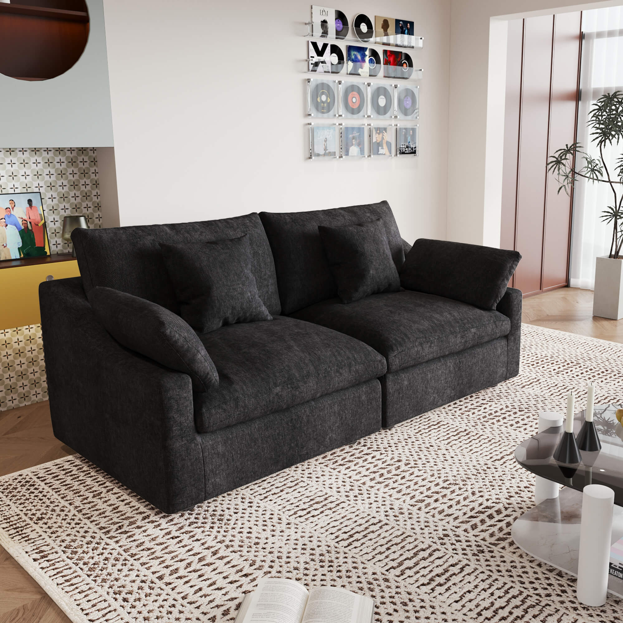 A black loveseat couch, featuring a minimalist design with removable cushions, placed in a room with modern decor.