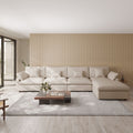 Modern living room with a khaki 5-seat sectional sofa with ottoman, wooden coffee table, and striped wall.