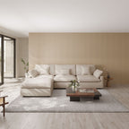 Modern living room with a khaki L-shaped sectional sofa, wooden coffee table, and striped wall.