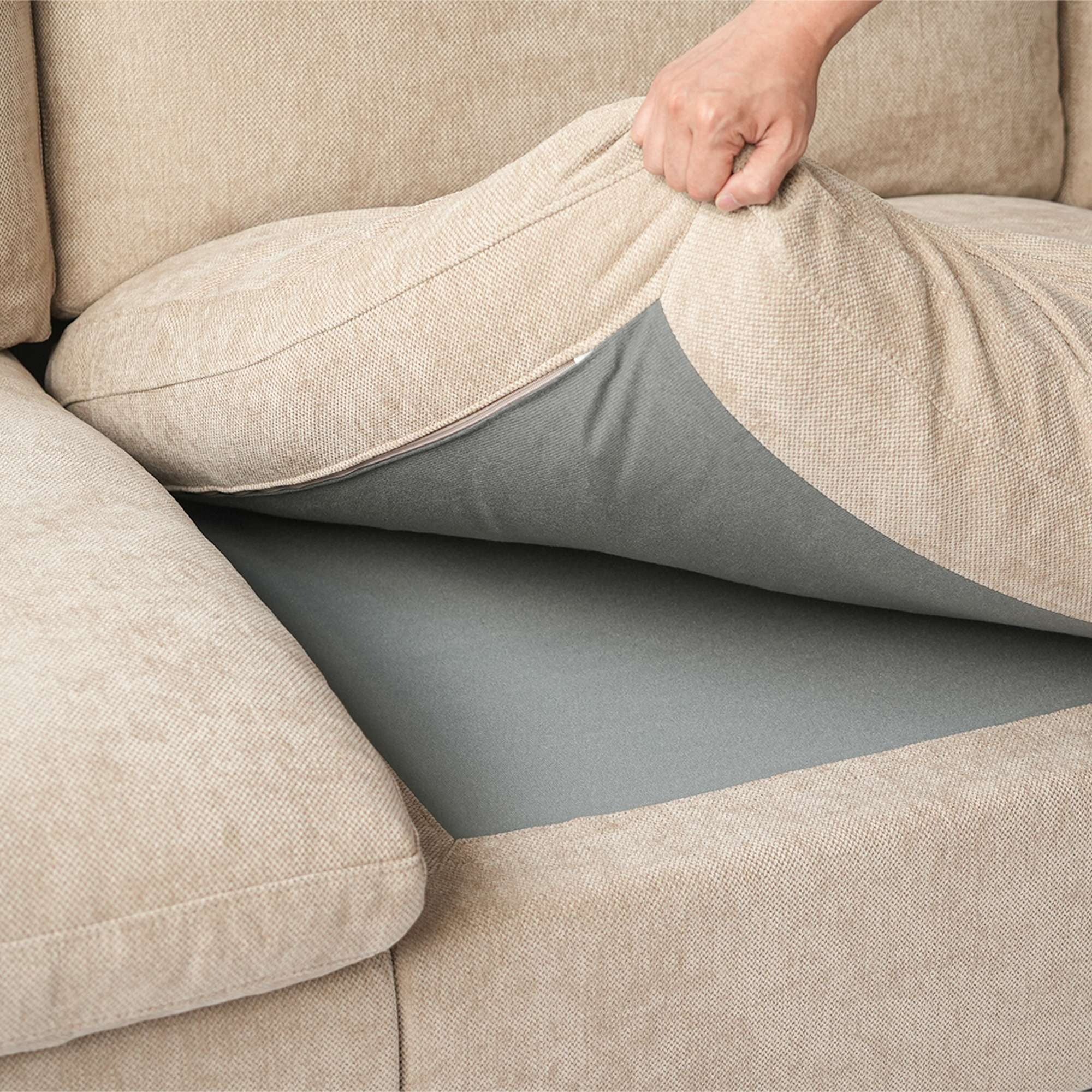 Person adjusting a khaki seat cushion over a sofa section.