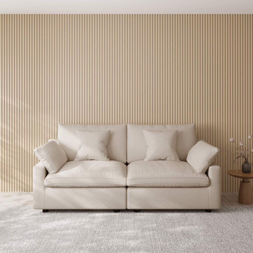 Khaki loveseat sofa in a room with a striped wall and small table.