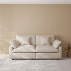 Khaki loveseat sofa in a room with a striped wall and small table.
