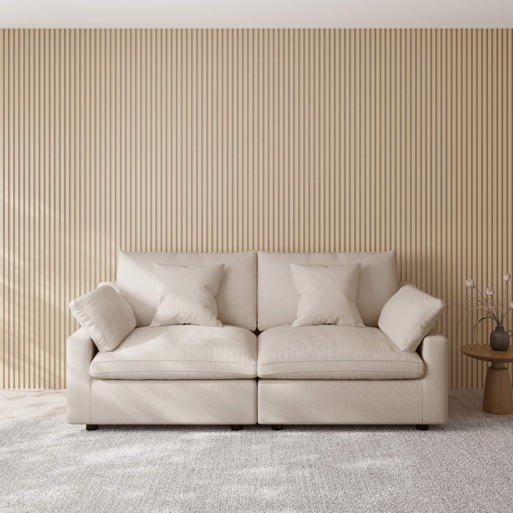 Khaki loveseat sofa in a room with a striped wall and small table.