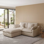 Khaki sectional chaise lounge sofa in a modern living room with striped wall and glass door.