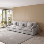 Light gray 3-seater couch in a modern living room with a wooden wall and large windows.