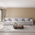 Light gray sectional sofa in a modern living room with a wooden coffee table and decorative elements.