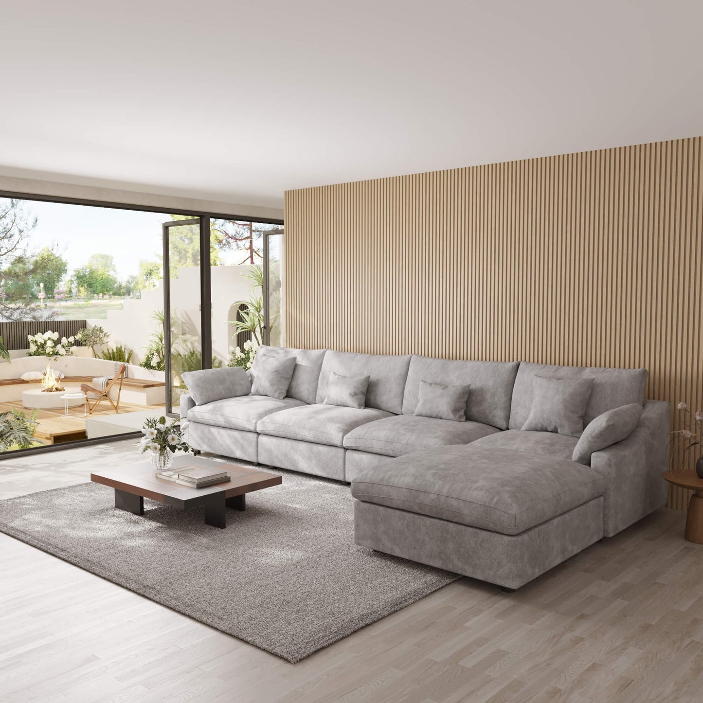 Light gray 5-seat sectional sofa with ottoman in a modern living room with large windows and a striped wall.