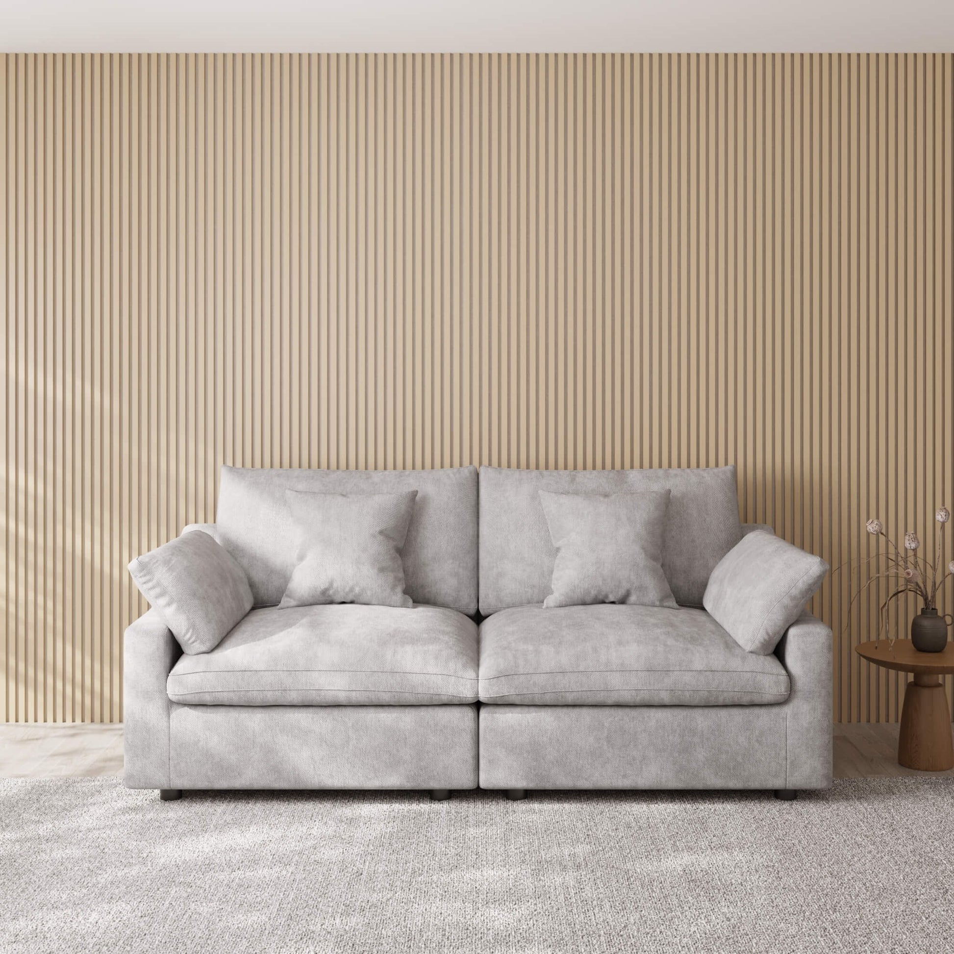 Gray loveseat sofa in a room with a striped wall and small table.