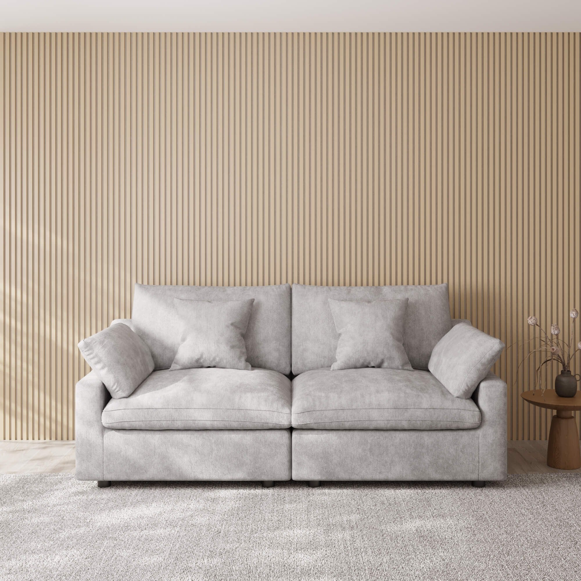 Gray loveseat sofa in a room with a striped wall and small table.