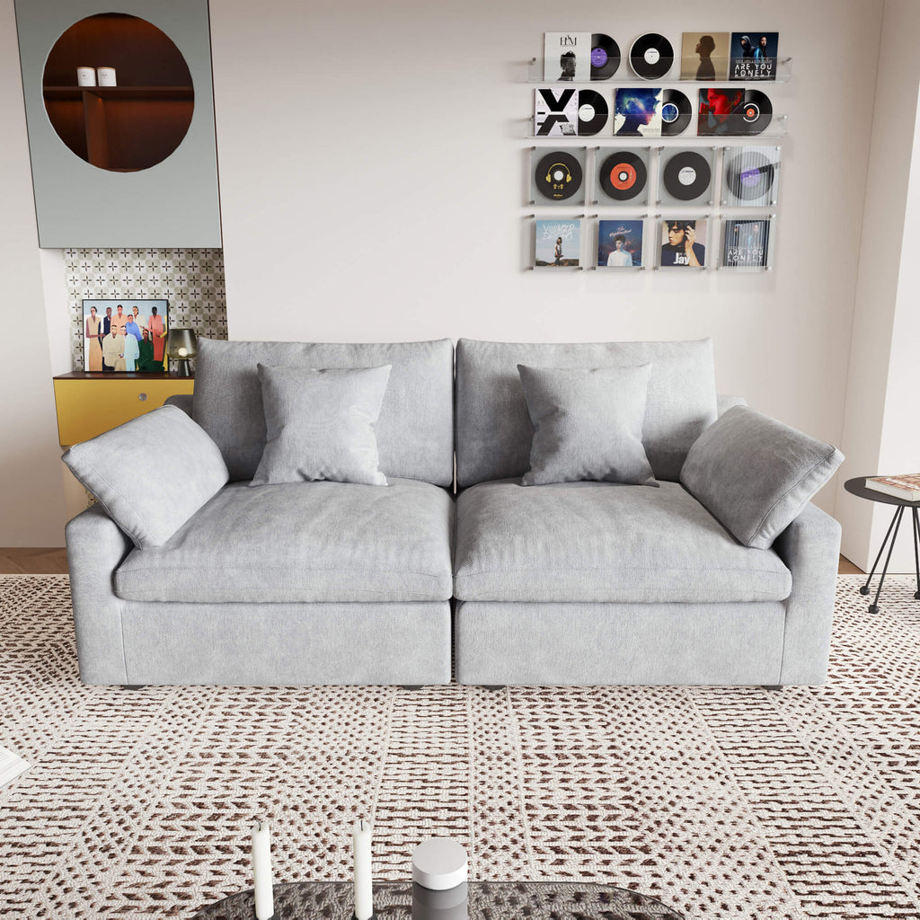 A light gray loveseat sofa, featuring a minimalist design with removable cushions, placed in a room with modern decor.
