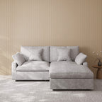 Light gray sectional chaise lounge sofa in a room with striped wallpaper