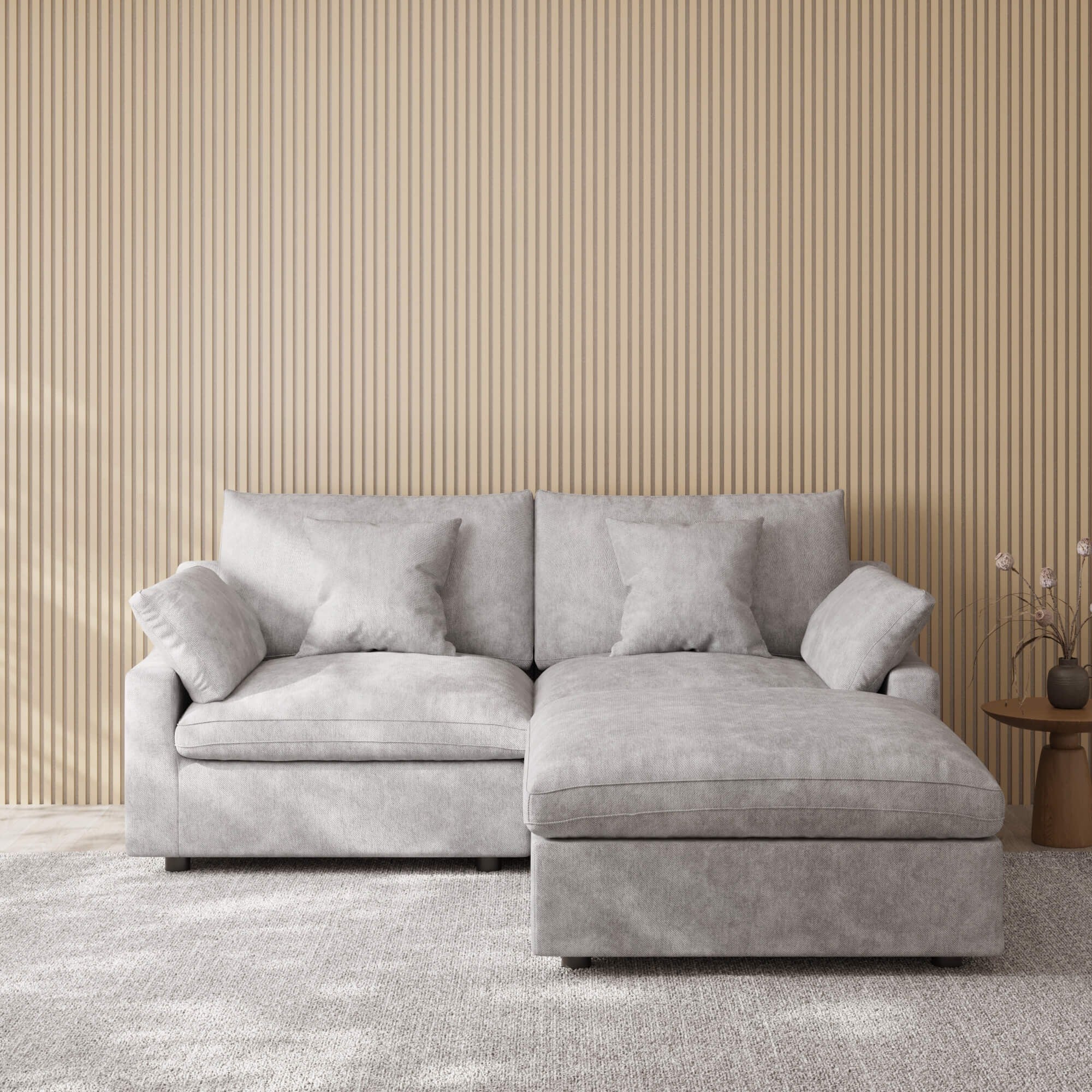 Light gray sectional chaise lounge sofa in a room with striped wallpaper